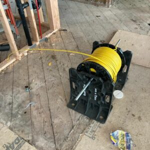 Rack-A-Tiers wire dispenser in use on a construction site to dispense a yellow wire reel.