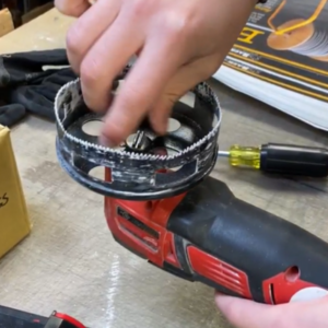 round hole saw attached to a red Milwaukee multi tool.